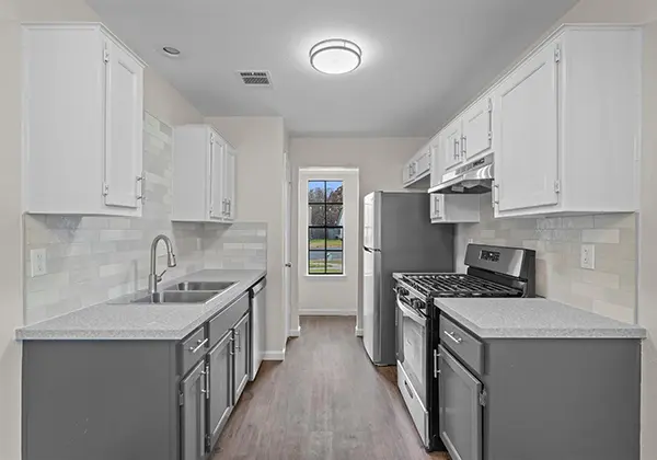 Kitchen after renovation in an Austin duplex with white cabinets, gray counters, and updated flooring (cash offer for duplex)